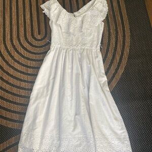 1950s-inspired white dress with a ruffle neckline and eyelet details